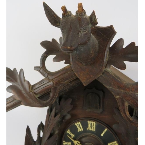 54 - A large Black Forest style cuckoo clock with carved hunting themed animals. Height 60cm.
Condition r... 