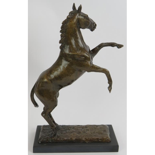 61 - A contemporary bronze figure of a rearing stallion mounted on a black slate plinth. Unsigned. Height... 