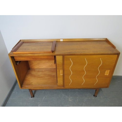 701 - A mid-century 1950s walnut & elm sideboard for Heal’s, the sliding doors opening onto a fitted inter... 