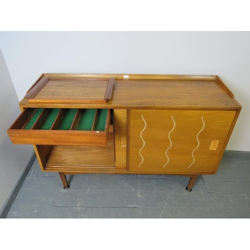 701 - A mid-century 1950s walnut & elm sideboard for Heal’s, the sliding doors opening onto a fitted inter... 