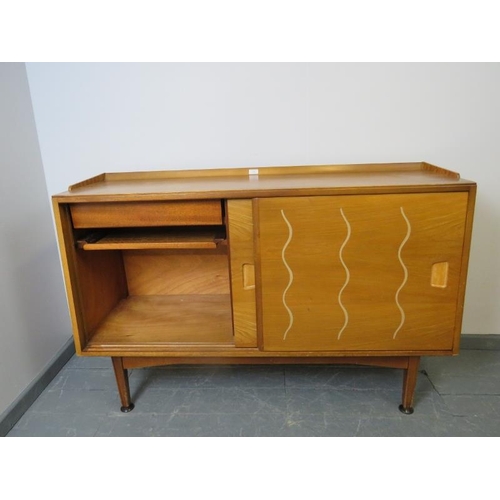 701 - A mid-century 1950s walnut & elm sideboard for Heal’s, the sliding doors opening onto a fitted inter... 