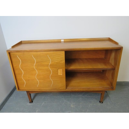 701 - A mid-century 1950s walnut & elm sideboard for Heal’s, the sliding doors opening onto a fitted inter... 