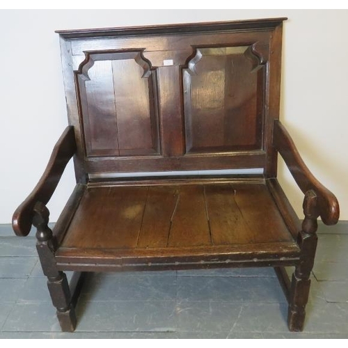 702 - A 17th century and later oak settle, with fielded back panels, on turned and block supports with str... 