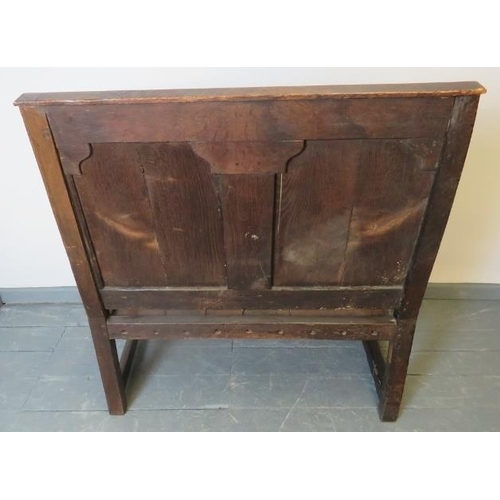 702 - A 17th century and later oak settle, with fielded back panels, on turned and block supports with str... 