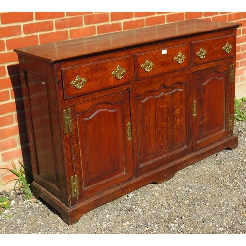 707 - An 18th century oak sideboard/dresser base, having 3 short frieze drawers above two shaped fielded p... 