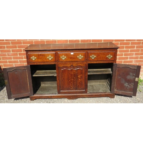 707 - An 18th century oak sideboard/dresser base, having 3 short frieze drawers above two shaped fielded p... 