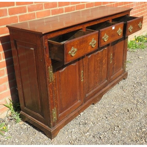 707 - An 18th century oak sideboard/dresser base, having 3 short frieze drawers above two shaped fielded p... 