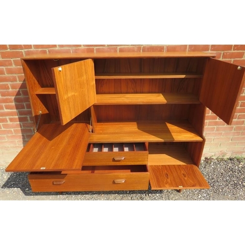 710 - A mid-century teak highboard by G Plan, featuring a fall front drinks cabinet, two cupboards and two... 