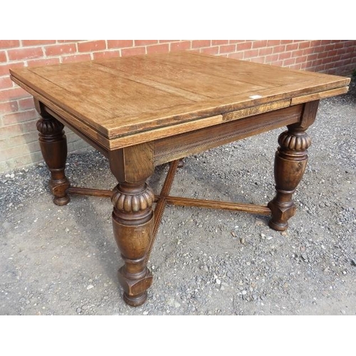 717 - An early 20th century medium oak draw leaf extending dining table, on baluster turned and fluted sup... 