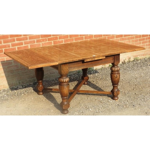 717 - An early 20th century medium oak draw leaf extending dining table, on baluster turned and fluted sup... 