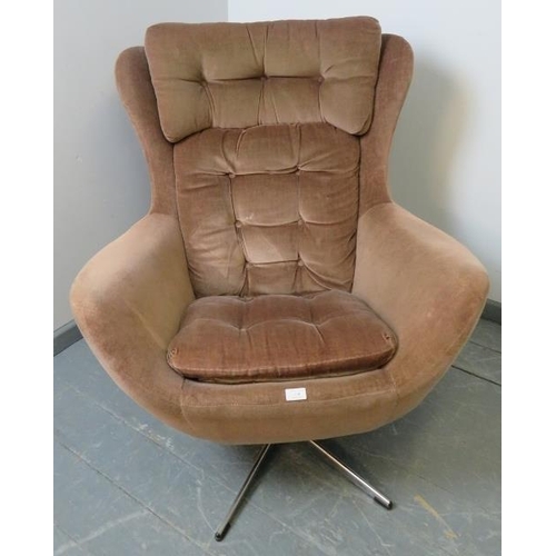 718 - A 1970s wingback ‘Blofeld’ style swivel chair, upholstered in buttoned brown draylon, on a chrome ba... 