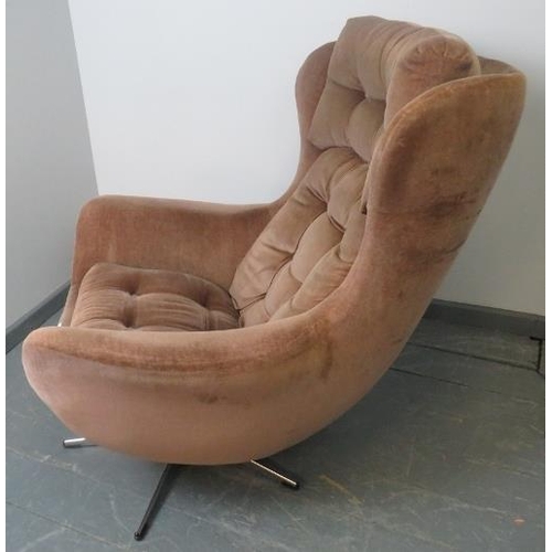 718 - A 1970s wingback ‘Blofeld’ style swivel chair, upholstered in buttoned brown draylon, on a chrome ba... 