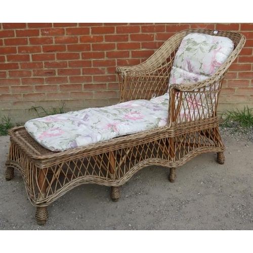 720 - A vintage wicker chaise long, with shaped backrest and apron, raised on eight supports bound with br... 