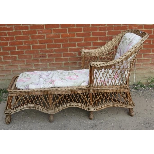 720 - A vintage wicker chaise long, with shaped backrest and apron, raised on eight supports bound with br... 