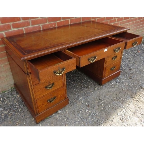 724 - An Edwardian medium oak pedestal desk with inset gilt tooled leather writing surface, housing a conf... 