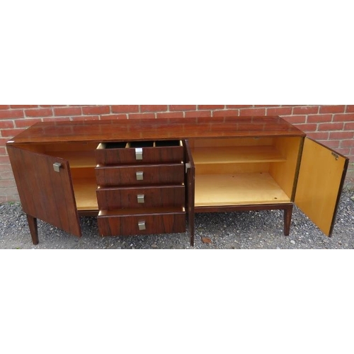 726 - A mid-century Danish tropical hardwood sideboard with sycamore lined interior, housing four short, g... 