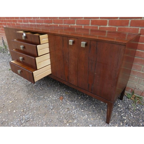 726 - A mid-century Danish tropical hardwood sideboard with sycamore lined interior, housing four short, g... 