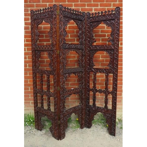 728 - An Arts & Crafts hardwood three section folding screen, ornately carved in the manner of Liberty & C... 