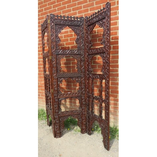 728 - An Arts & Crafts hardwood three section folding screen, ornately carved in the manner of Liberty & C... 