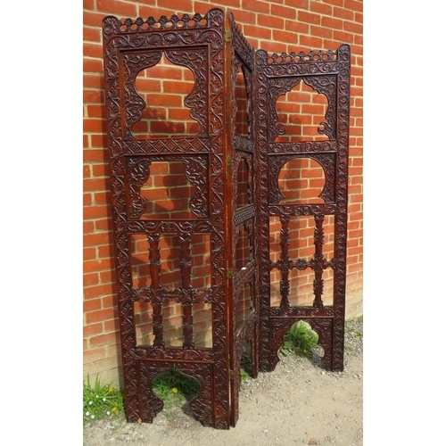 728 - An Arts & Crafts hardwood three section folding screen, ornately carved in the manner of Liberty & C... 