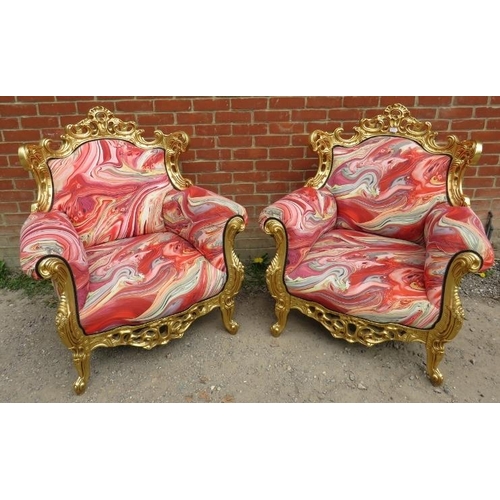 729 - A pair of very ornate giltwood armchairs, the frames carved and pierced in the Rococo style, upholst... 