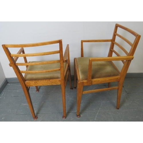 732 - A pair of Art Deco light oak open sided elbow chairs, with drop-in seat pads, on tapering square sup... 