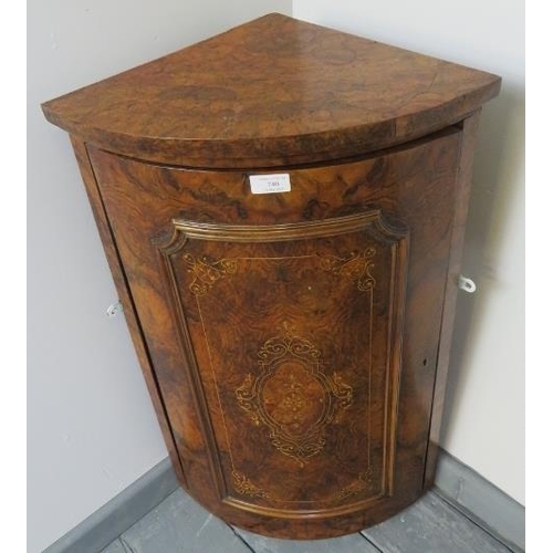 740 - A Victorian burr walnut bow fronted wall hanging corner cupboard featuring marquetry inlay, with fit... 