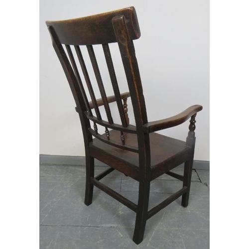 754 - A Georgian oak country made elbow chair with turned spindles, on square supports with stretchers. 
C... 