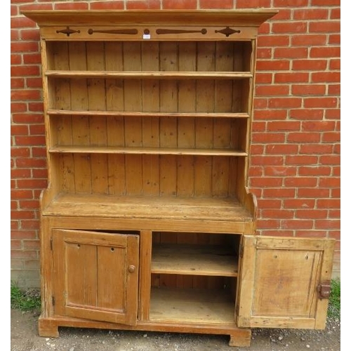 760 - An antique pine kitchen dresser with carved and pierced cornice over plate rack shelving, over a dou... 