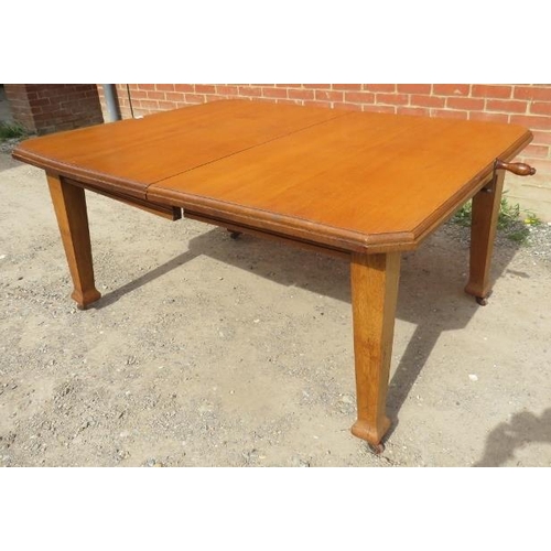 761 - An Arts & Crafts light oak wind-out extending dining table with two additional leaves, on tapering s... 