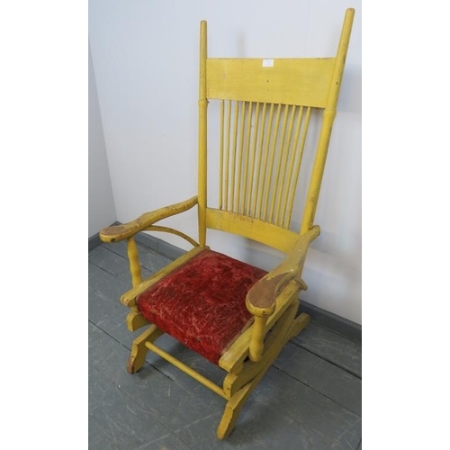 774 - A turn of the century American Arts & Crafts ‘Dexter’ rocking chair, with spindle back and shaped ar... 