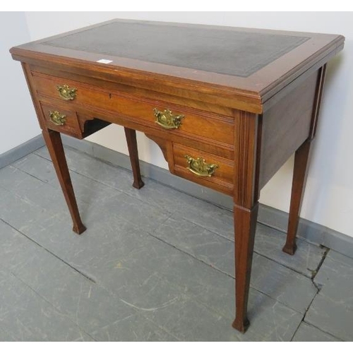 803 - An Edwardian mahogany turnover card table, with inset tooled leather writing surface, housing one lo... 