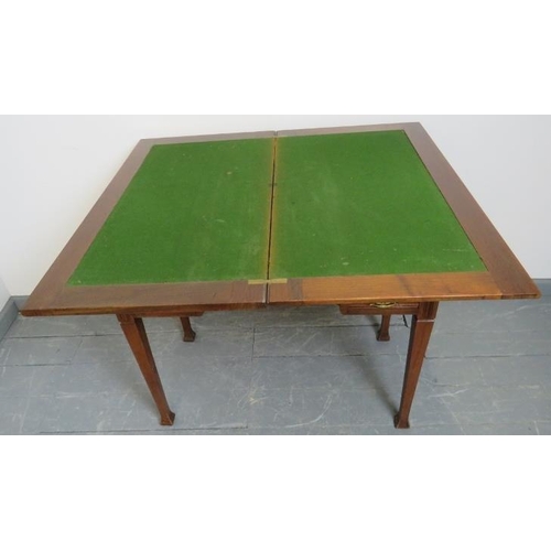 803 - An Edwardian mahogany turnover card table, with inset tooled leather writing surface, housing one lo... 