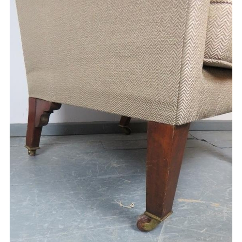 820 - A large Edwardian wingback armchair in the Georgian taste, on tapering square mahogany supports with... 