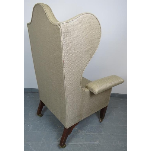 820 - A large Edwardian wingback armchair in the Georgian taste, on tapering square mahogany supports with... 