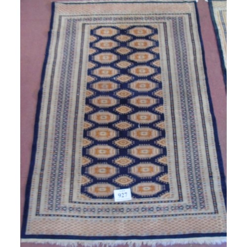 927 - A mid 20's Persian rug. A repeat central pattern orange on black with pale borders. 186cm x 126cm (a... 