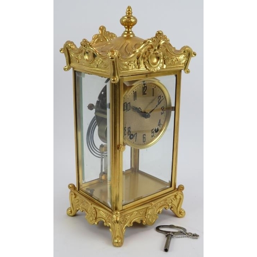 101 - An ornate gilt 8 day striking mantle clock with mercury style pendulum and glazed case. Height 35cm.... 