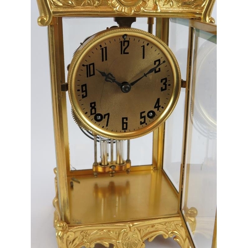 101 - An ornate gilt 8 day striking mantle clock with mercury style pendulum and glazed case. Height 35cm.... 