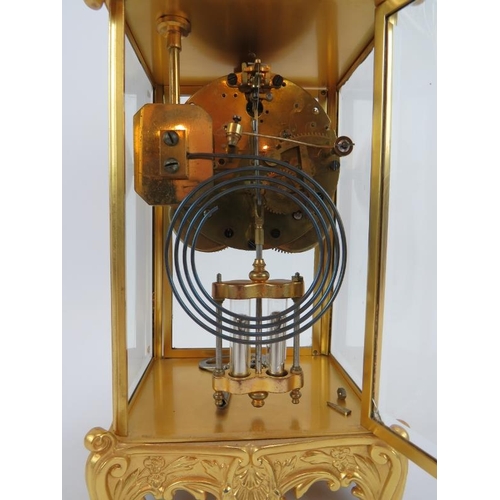 101 - An ornate gilt 8 day striking mantle clock with mercury style pendulum and glazed case. Height 35cm.... 