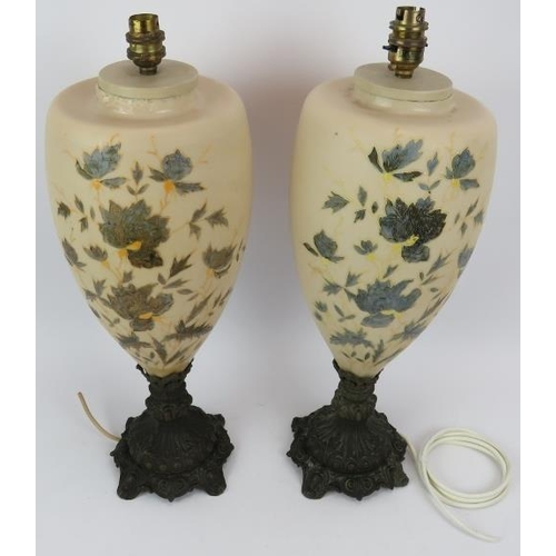 112 - A pair of 1920s French glass lamps decorated with blue floral enamel design and standing on cast met... 