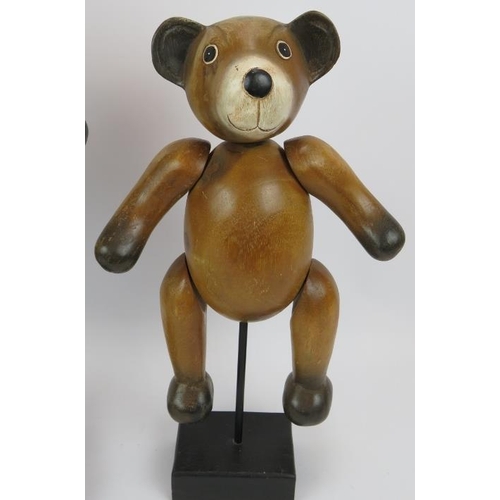 118 - Two carved hardwood jointed teddy bears mounted on black wooden plinths. Tallest 62cm. (2).
Conditio... 