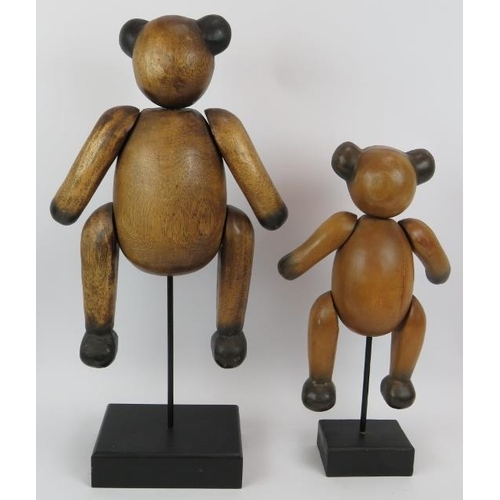 118 - Two carved hardwood jointed teddy bears mounted on black wooden plinths. Tallest 62cm. (2).
Conditio... 