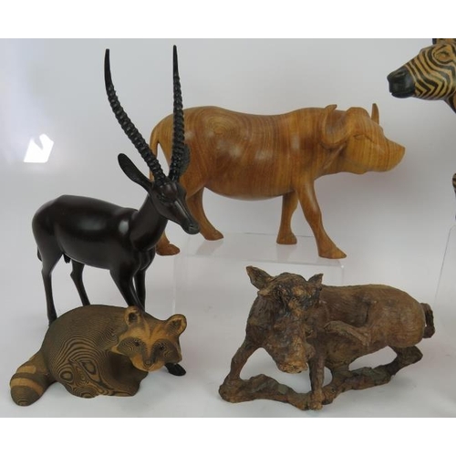 179 - Seven hand carved animal figures including wart hogs, zebra, water buffalo, impala, racoon and eleph... 