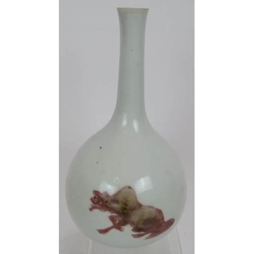 31 - An antique Chinese porcelain bottle vase in white glaze bearing pink decoration of two temple lions ... 