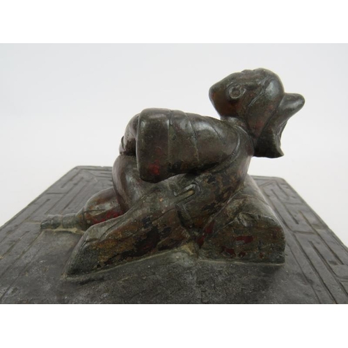 34 - An antique Chinese bluestone carving of a reclining female with bound feet in the centre of a slab w... 