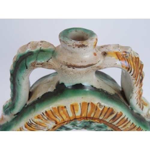 37 - An early European Majolica pottery flask in green and amber tin glaze and with twin pinched handles.... 