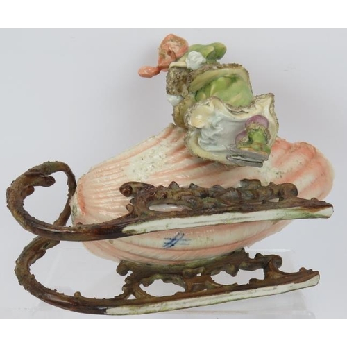 62 - A late 19th century continental porcelain figure of a girl with shell shaped sleigh, blue crossed ma... 