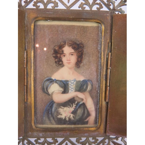 64 - An early 19th century portrait miniature of a girl, watercolour on card, mounted in a gilt brass eas... 