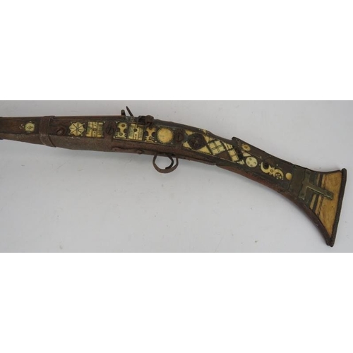 9 - An Antique Middle-Eastern Jezail flint lock rifle with ornately inlaid bone and brass stock, Length:... 