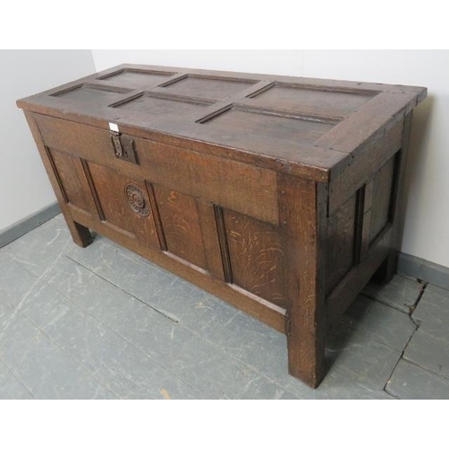 703 - A 17th century panelled oak coffer with fielded panels to top and all four sides and carved central ... 